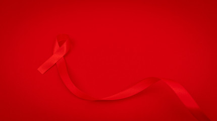 Aids Awareness Red heart Ribbon on red background .