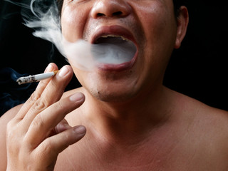 A man holding cigarette. Nicotine destroy teeth and gum healthy. it make effect Yellow stain, Tooth decay and Bad breath. world no tobacoo day.