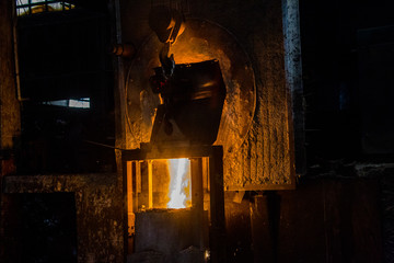 metal casting process with red high temperature fire in metal part factory