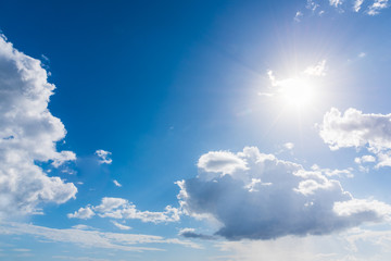 Fototapeta na wymiar Sun shining in a blue sky with white clouds