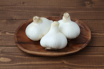 木のテーブルにのせた 生のニンニク ガーリック 木の皿