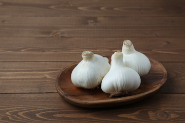 木のテーブルにのせた 生のニンニク ガーリック 木の皿