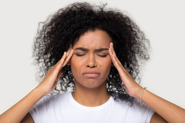 Studio portrait young african female touch temples suffers from headache