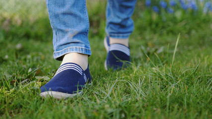 young man in red sneakers goes on a meadow