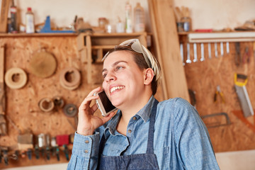 Handwerker Azubi mit Smartphone in der Hotline