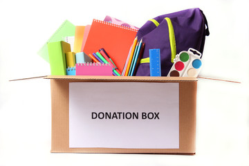 donation box with school stationery items isolated on white