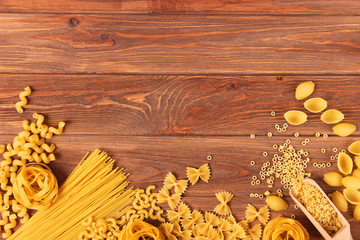 A set of different types of Italian pasta on a colored background top view, place for text.