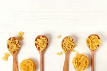 A set of different types of Italian pasta on a colored background top view, place for text.