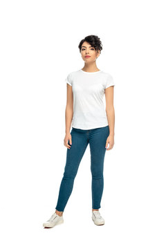 attractive latin brunette woman standing in blue jeans and white t-shirt isolated on white