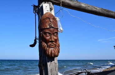 Strange totem mask on the cost of the lake