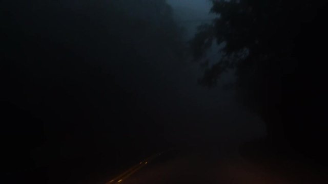 Driving Car in Dense Fog in the Evening. Bad Weather Condition with Zero Visability. Perspective View from Cabin