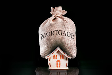 Have Heavy Home Loan. Bag with money for mortgage. Mortgage pressure on house. big rental concept.
