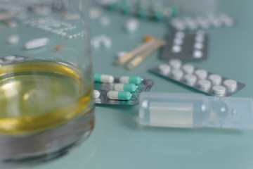 set of loose pills and complete tablets on green glass table