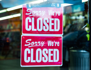 Sorry we're closed signs in a retail store window