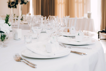 Table setting for a wedding ceremony at swimming pool. round table with white tablecloth
