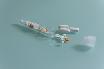 set of loose pills and complete tablets on green glass table