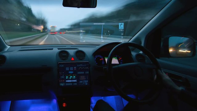 The male driving a car with a virtual navigator in the evening city. Hyperlapse