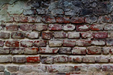 Texture of a very old peeling red brick wall covered with plaster closeup. time breaking background