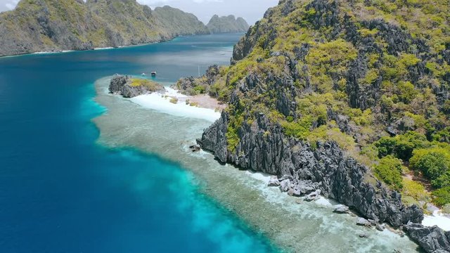 Star beach on Tapiutan island near Matinloc shrine. El Nido, Palawan, Philippines. Beautiful Landscape with Limestone rocks, paradise like beaches and coral reef edge