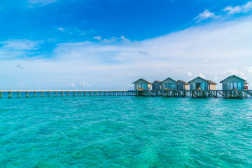 Beautiful water villas in tropical Maldives island at the sunset time .