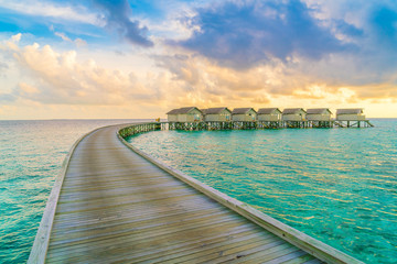Fototapeta na wymiar Beautiful water villas in tropical Maldives island at the sunset time .