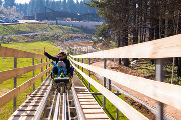 young father and son driving alpine coaster