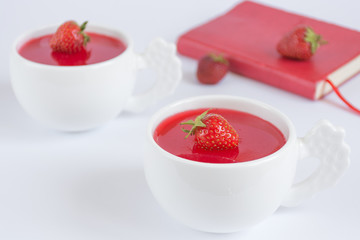 Vegetarian panacotta with strawberry and coconut milk in white cups on white background
