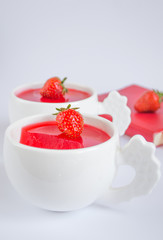 Vegetarian panacotta with strawberry and coconut milk in white cups on white background