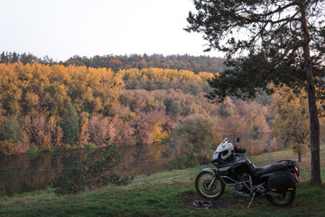 Obraz premium Adventure motorcycle, Motorcyclist gear, A motorbike driver concept of active lifestyle, enduro travel road trip, transportation wallpaper background, tourist. autumn evening, copy space