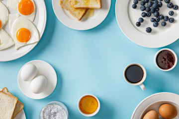 top view of table setting for breakfast on blue background
