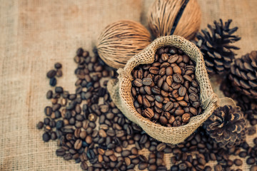 Roasted coffee beans in a sack on dark background