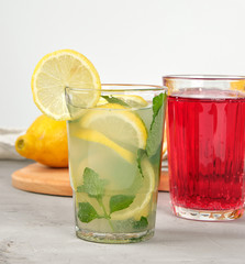 lemonade with lemons, mint leaves, lime in a glass and red berry lemonade