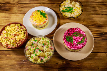 Set of festive mayonnaise salads on wooden table