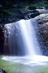 Waterfall blurred and falling down in a dark stone cave