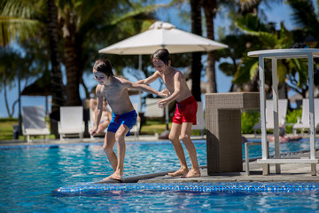 Naklejka premium Happy children, brothers, having fun in the pool