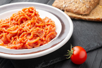 Vermicelli in tomato sauce on a dark background