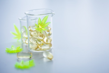 Pillen, Tabletten, Kapseln mit Cannabis Marihuana Hanf und CBD in Labor Becherglas gegen Schmerzen zur Therapie als Medizin 