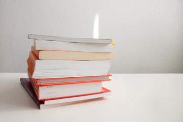 books in a pile on top of each other lie on a white background close-up