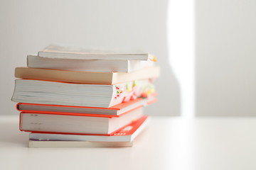 books in a pile on top of each other lie on a white background close-up