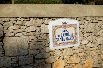 Straßenschild aus Azulejos an einer Steinmauer in Cascais