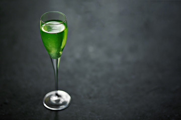 Absinthe in a glass on black background