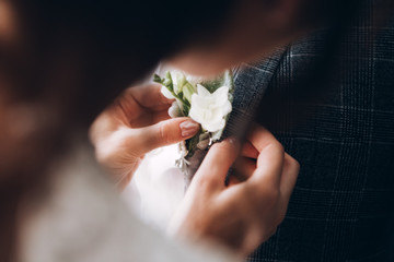 stylish groomsmen helping happy groom getting ready in the morning for wedding ceremony. luxury man in suit in room. wedding day.