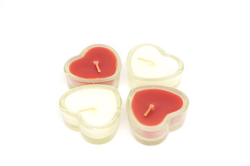 four heart shaped candles isolated white background