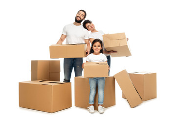 cheerful latin parents holding boxes and standing near cute daughter isolated on white