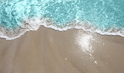 Fototapeta na wymiar Soft wave of turquoise sea water on the sandy beach.