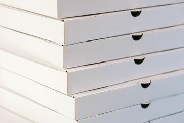 A large stack of white pizza boxes