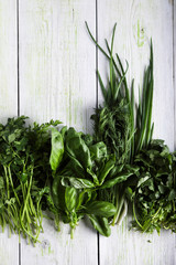 Herbs, basil, parsley, dill, green onion on wooden background