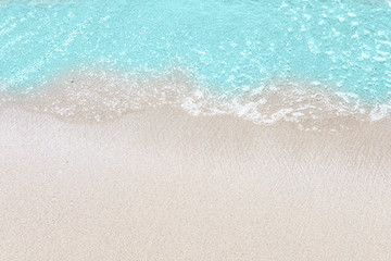 Fototapeta na wymiar Soft wave of turquoise sea water on the sandy beach.