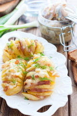 Harmonium potato with bacon and cheese on a white plate, selective focus
