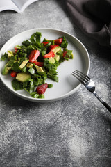 Salad with spinach, strawberries and avocado Top view.
